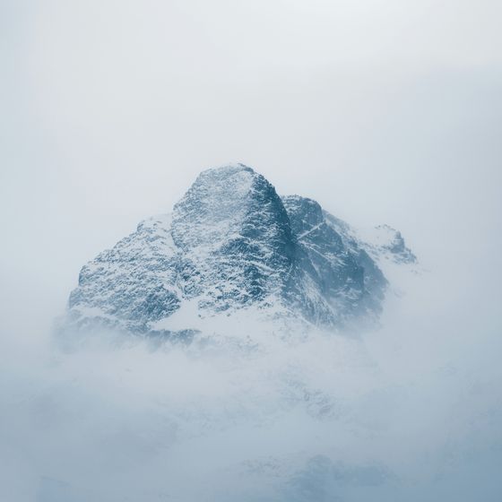 A snow-covered mountain peak in haze